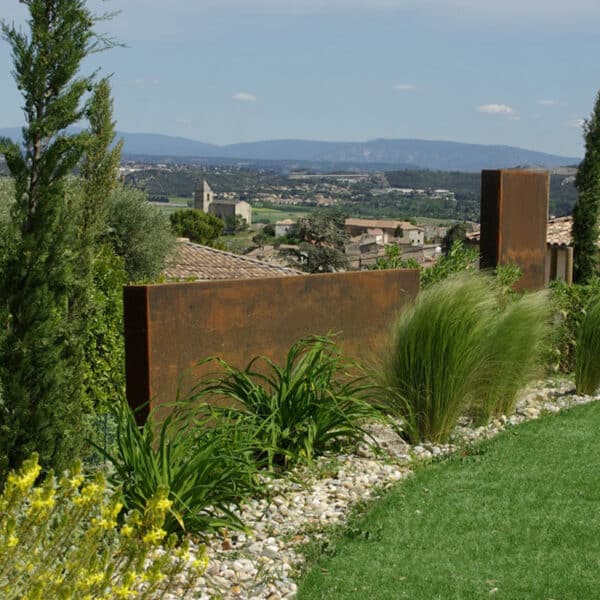 Brises vues rectangulaire en acier corten disposé dans un jardin