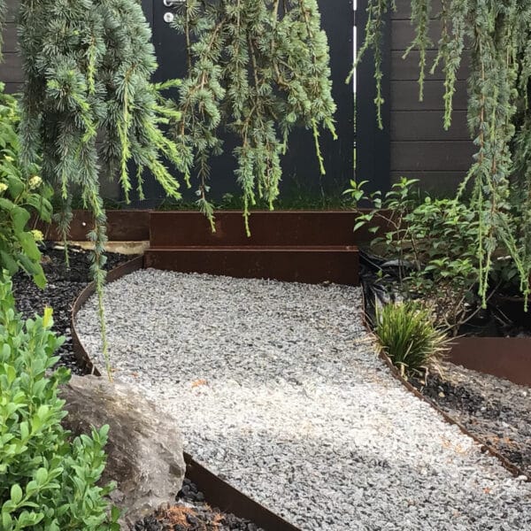 Escaliers en acier corten comportant deux marches dans un jardin