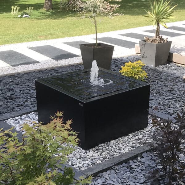 table d'eau carré en aluminium peint disposée dans un jardin