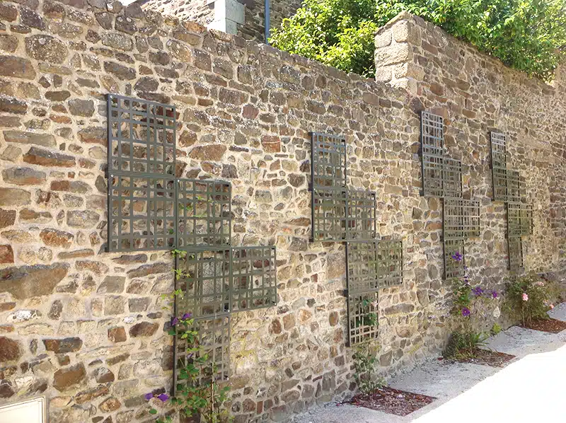 ATECH-Treillage-C-NATURA Photo d'un mur en pierre avec treillage en métal gris